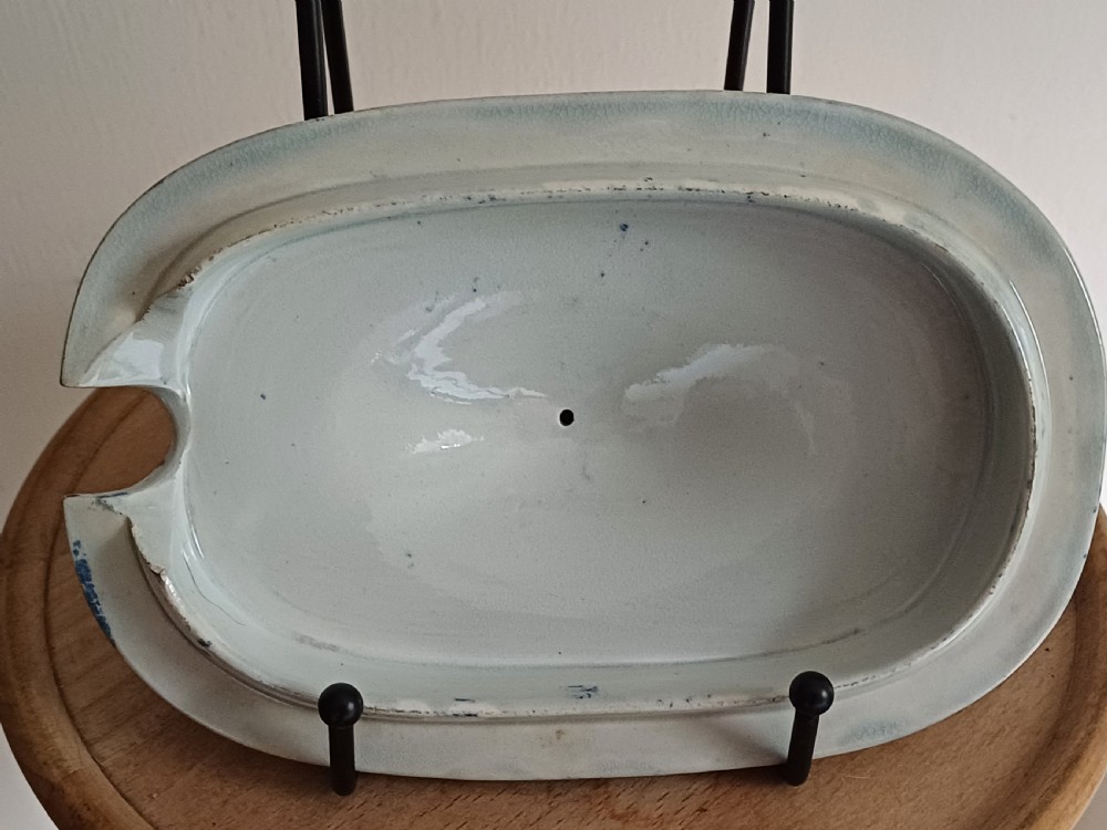 A Georgian blue and white transfer-printed ceramic sauce tureen featuring floral patterns, lion head side handles, a lion finial lid, and a matching underplate. View XVI