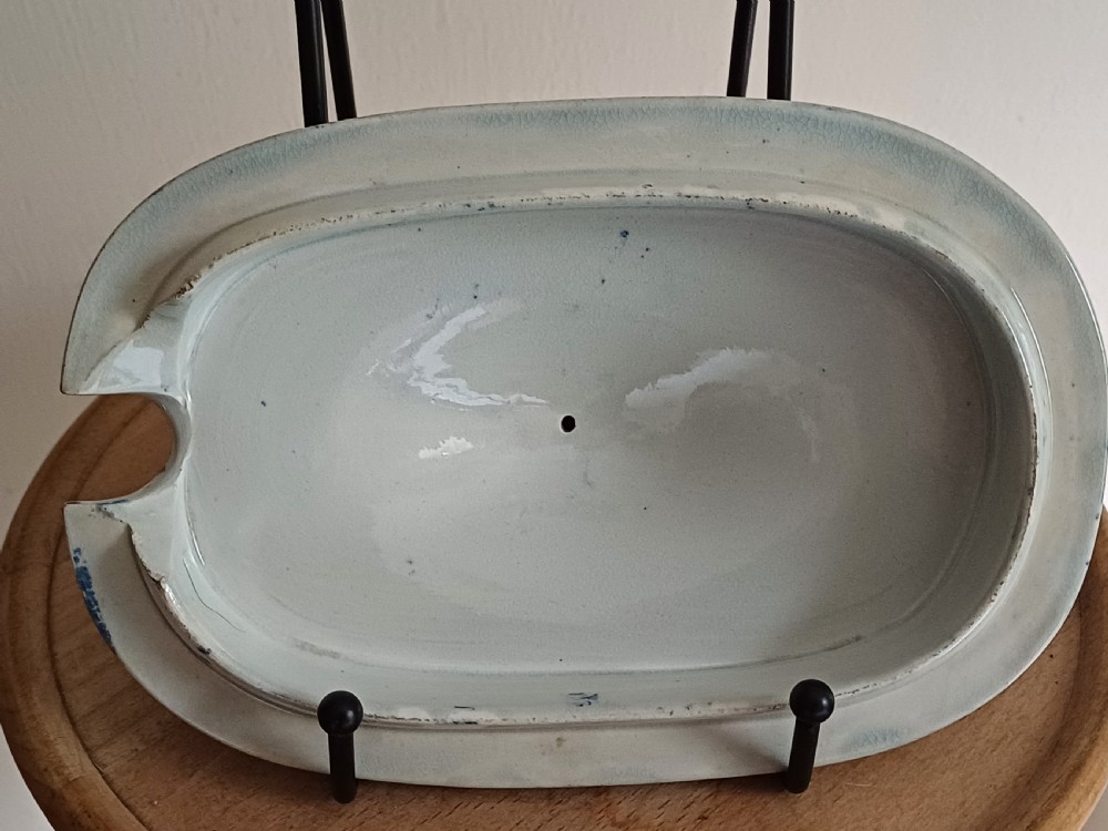 A Georgian blue and white transfer-printed ceramic sauce tureen featuring floral patterns, lion head side handles, a lion finial lid, and a matching underplate. View XVII