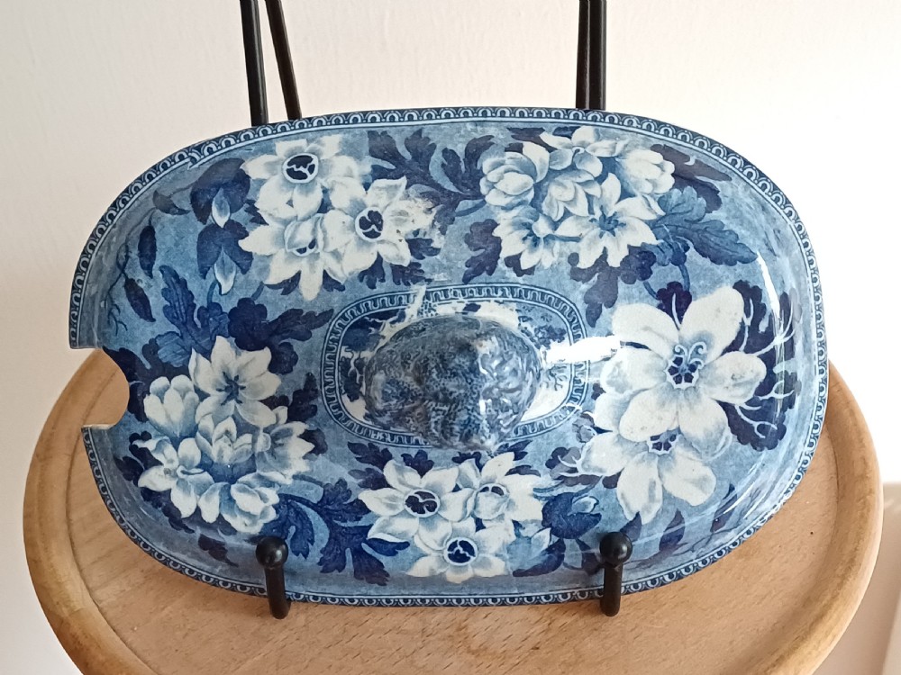 A Georgian blue and white transfer-printed ceramic sauce tureen featuring floral patterns, lion head side handles, a lion finial lid, and a matching underplate. View XVIII