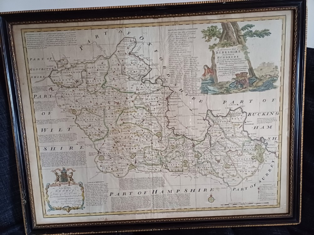 A framed 18th-century hand-coloured map of Berkshire by Emanuel Bowen featuring historical text cartouches and a dark wooden frame.