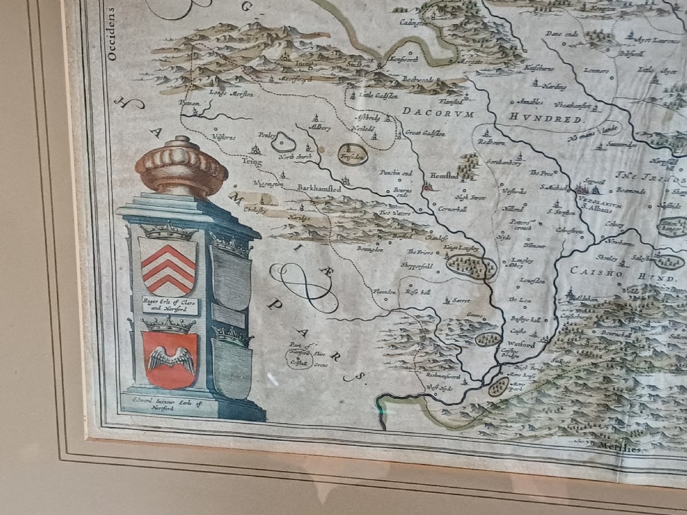 A framed 17th-century hand-coloured map of Hertfordshire by cartographer Jan Blaeu featuring decorative heraldic coats of arms and a title cartouche. View VI