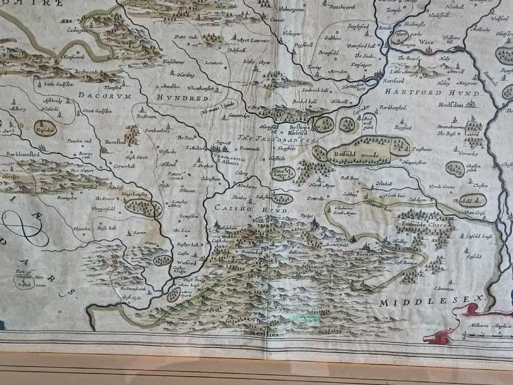 A framed 17th-century hand-coloured map of Hertfordshire by cartographer Jan Blaeu featuring decorative heraldic coats of arms and a title cartouche. View VII