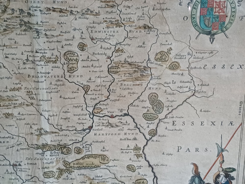 A framed 17th-century hand-coloured map of Hertfordshire by cartographer Jan Blaeu featuring decorative heraldic coats of arms and a title cartouche. View IX