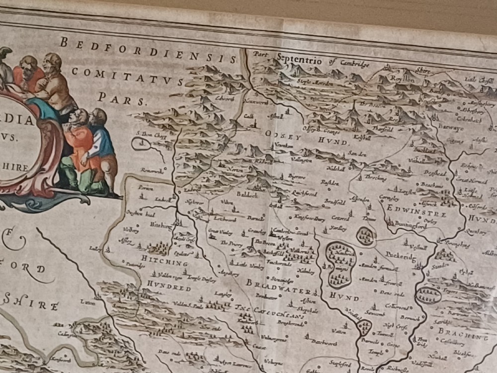 A framed 17th-century hand-coloured map of Hertfordshire by cartographer Jan Blaeu featuring decorative heraldic coats of arms and a title cartouche. View XIII