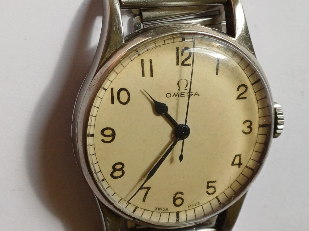 Vintage Omega 6B159 military pilot wristwatch with a cream dial, Arabic numerals, and a stainless steel case. View V