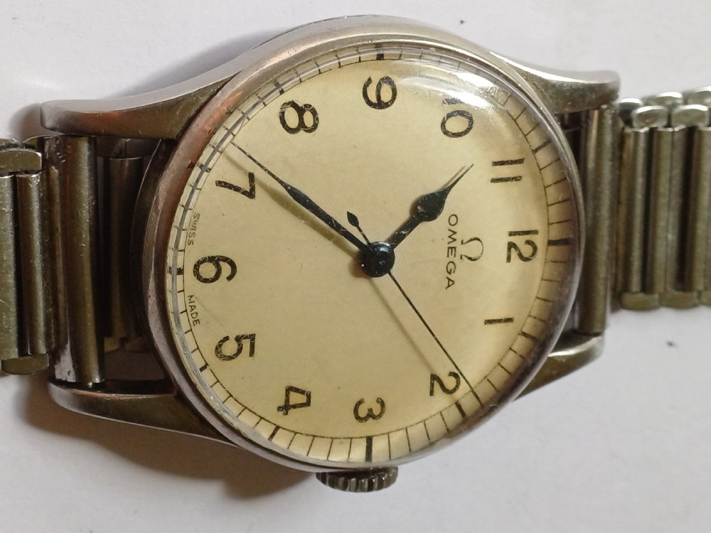 Vintage Omega 6B159 military pilot wristwatch with a cream dial, Arabic numerals, and a stainless steel case. View VI