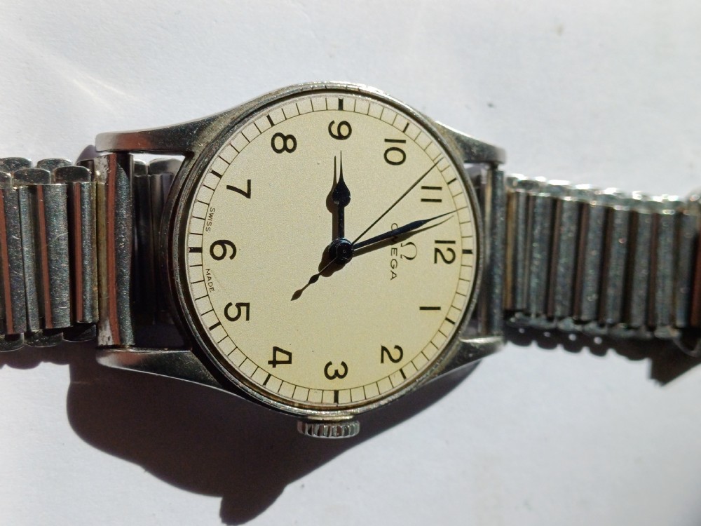Vintage Omega 6B159 military pilot wristwatch with a cream dial, Arabic numerals, and a stainless steel case. View VIII