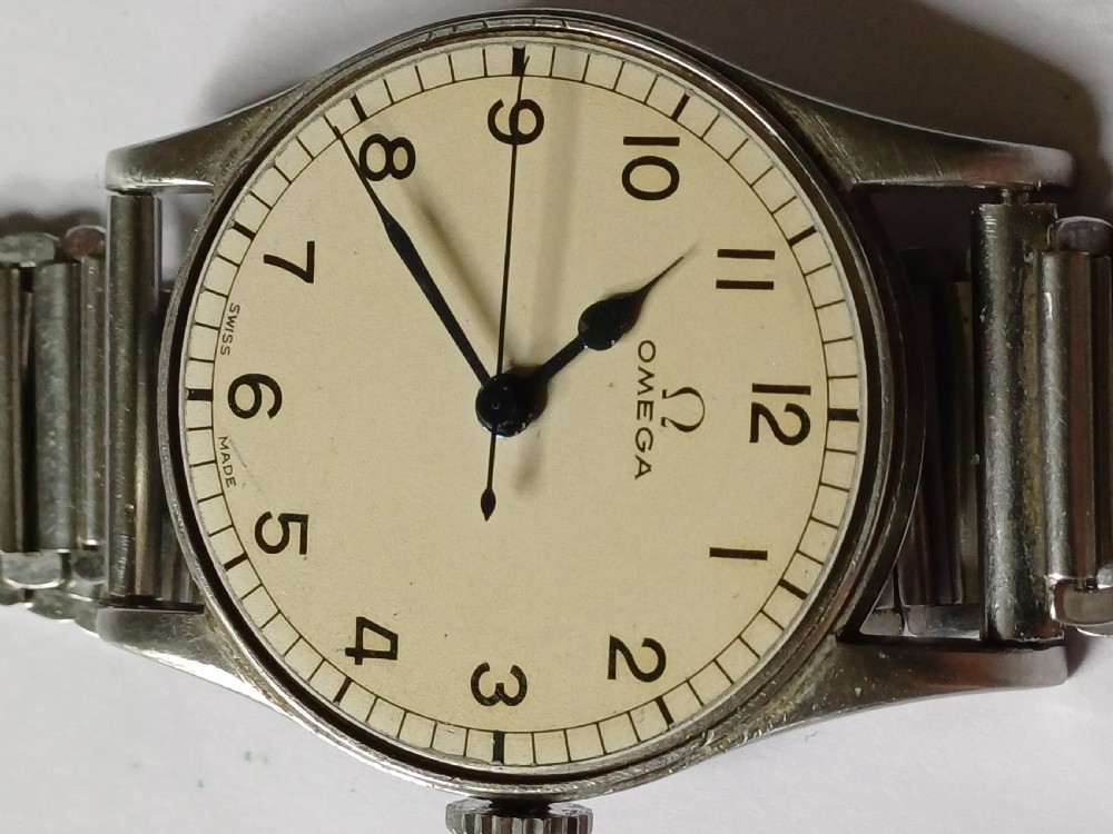 Vintage Omega 6B159 military pilot wristwatch with a cream dial, Arabic numerals, and a stainless steel case. View XI