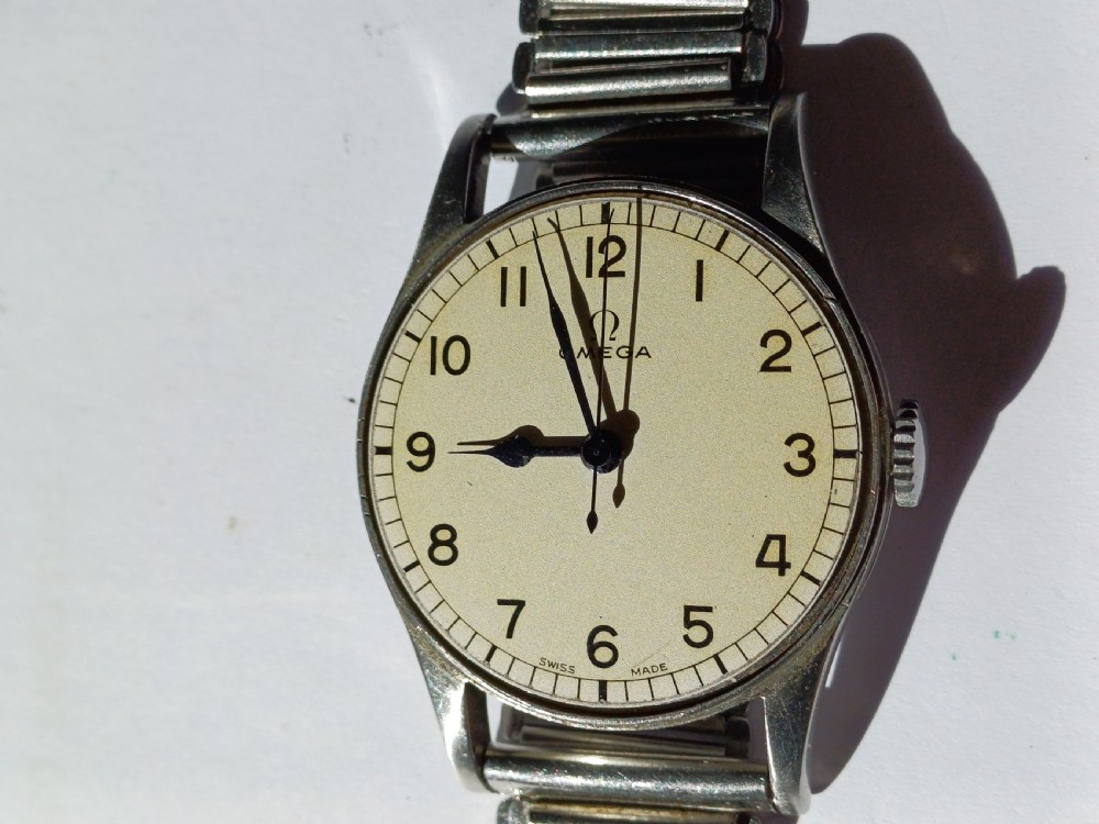 Vintage Omega 6B159 military pilot wristwatch with a cream dial, Arabic numerals, and a stainless steel case. View XVI