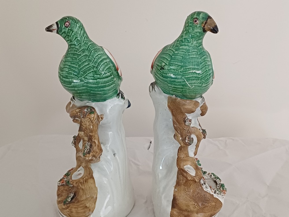 Reserved AD A rare pair of Staffordshire figures of a bird, possibly a pigeon or dove, seated on a tree with a nest of eggs below. Each one is brightly painted and dating circa 1860 View IX