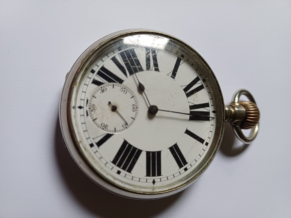 An antique open-face silver pocket watch featuring a white enamel dial with bold black Roman numerals and a subsidiary seconds dial. View III