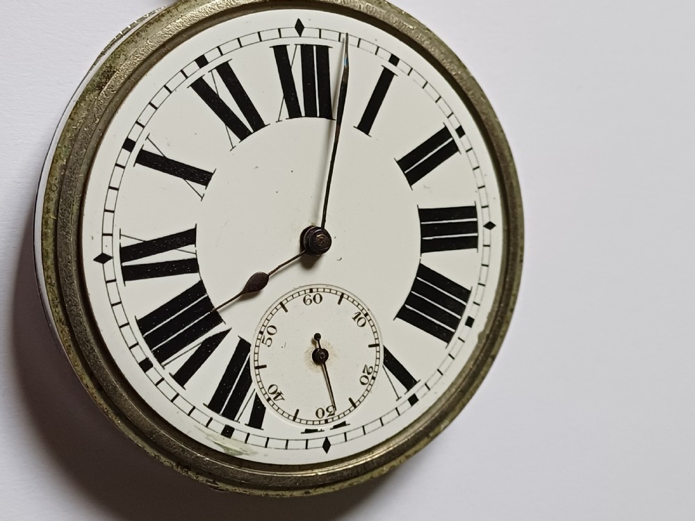 An antique open-face silver pocket watch featuring a white enamel dial with bold black Roman numerals and a subsidiary seconds dial. View VI