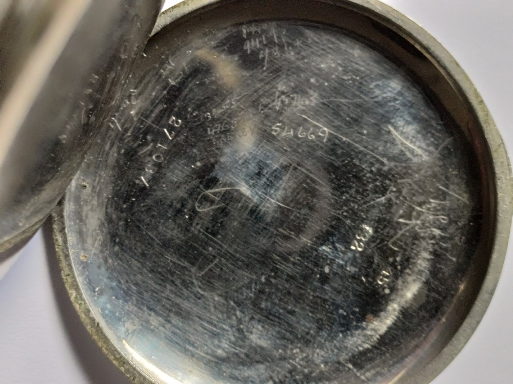 An antique open-face silver pocket watch featuring a white enamel dial with bold black Roman numerals and a subsidiary seconds dial. View X