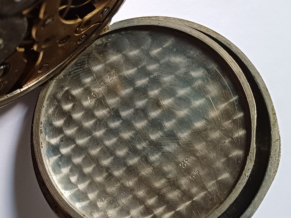An antique open-face silver pocket watch featuring a white enamel dial with bold black Roman numerals and a subsidiary seconds dial. View XII