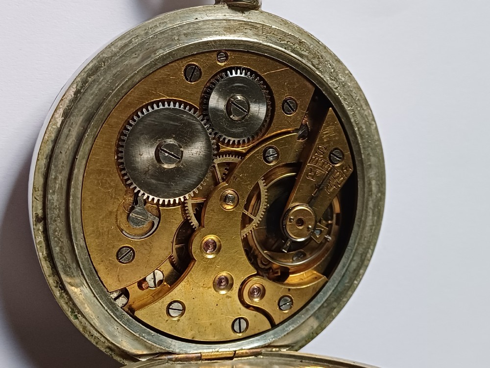 An antique open-face silver pocket watch featuring a white enamel dial with bold black Roman numerals and a subsidiary seconds dial. View XIII