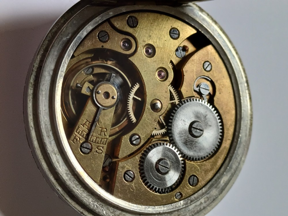 An antique open-face silver pocket watch featuring a white enamel dial with bold black Roman numerals and a subsidiary seconds dial. View XVI