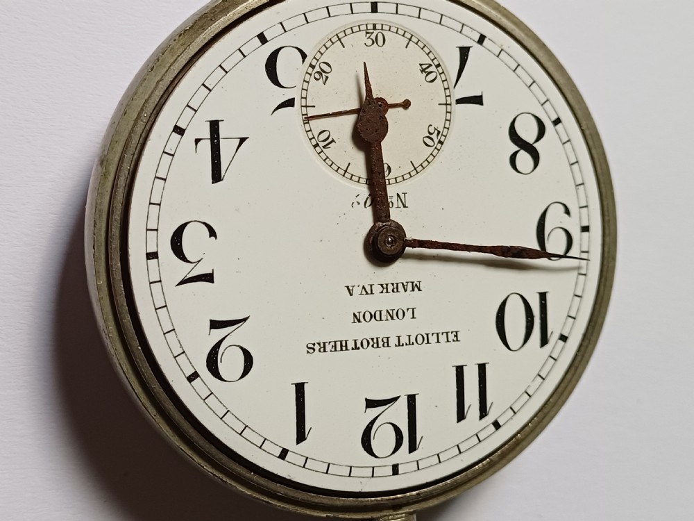 An antique First World War era military pocket watch with a white enamel dial, black Arabic numerals, and a nickel-plated metal case. View VIII