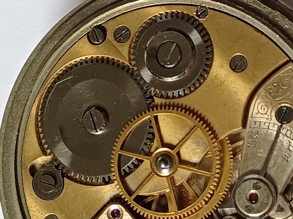 An antique First World War era military pocket watch with a white enamel dial, black Arabic numerals, and a nickel-plated metal case. View XVIII