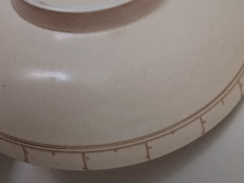 A round Art Deco earthenware bowl featuring a central circular spider-web trellis design surrounded by tube-lined floral motifs in orange and beige. View XIII