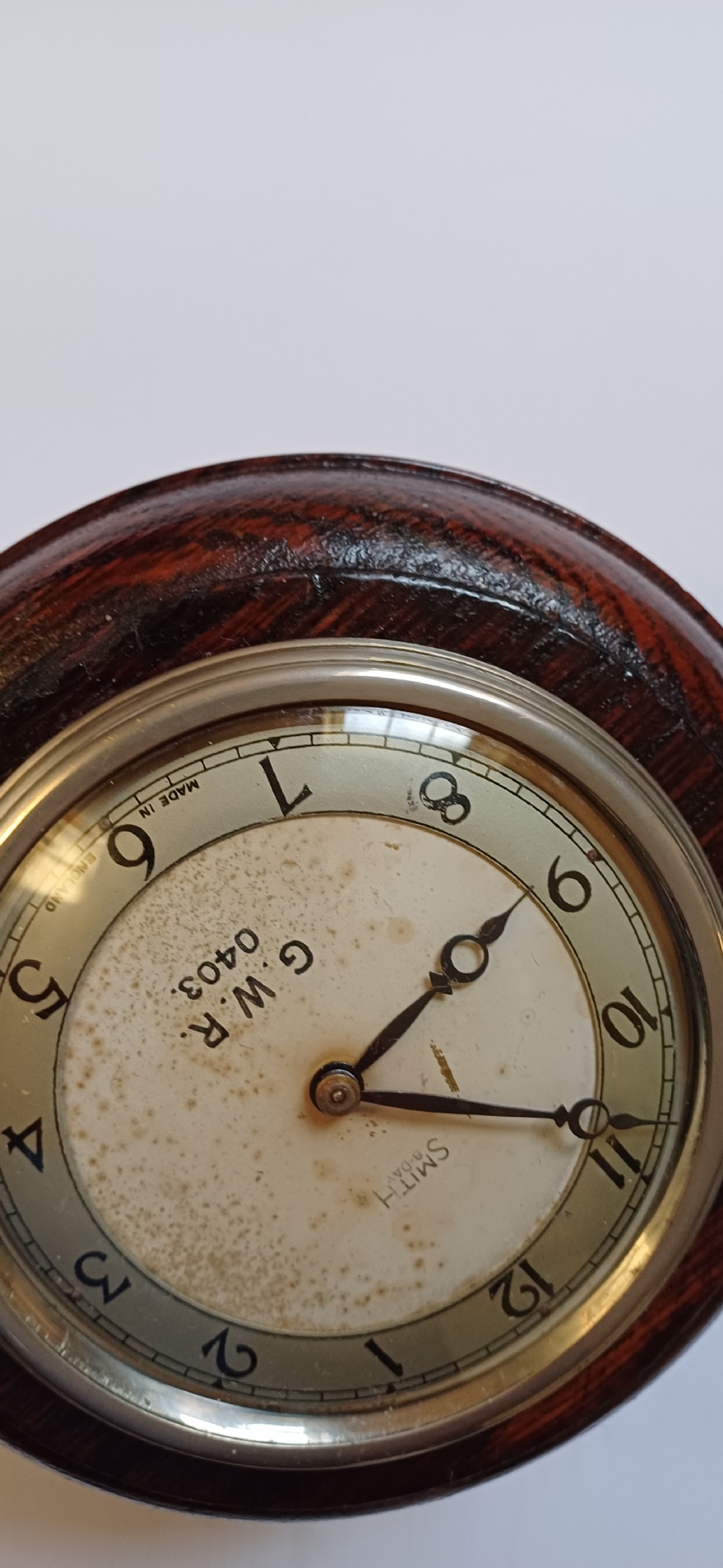 A circular dark oak GWR signal box clock featuring a brass bezel, glass face cover, cream dial with Arabic numerals, and black clock hands. View XVI