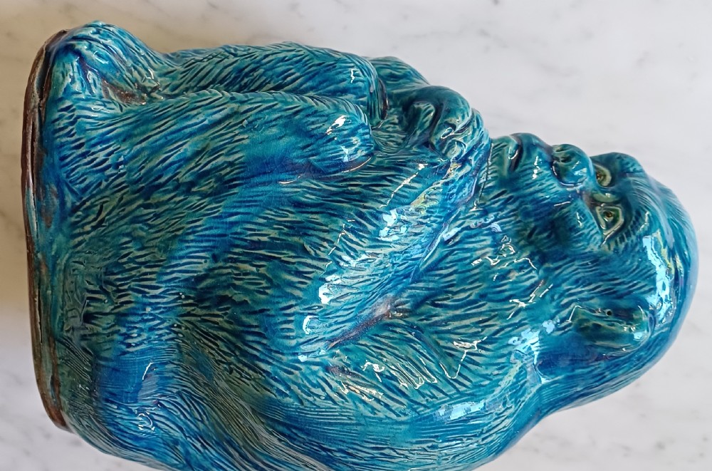 An early 20th-century Chinese ceramic figurine depicting a seated ape with a rich turquoise glaze and detailed fur texture. View IX