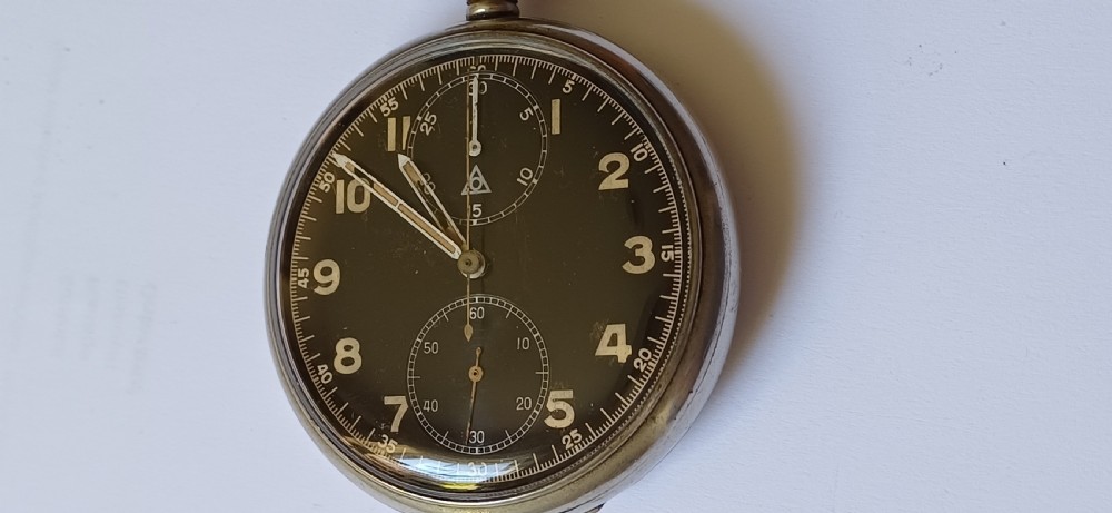 An open-face pocket watch featuring a black dial, luminescent white Arabic numerals, two sub-dials, and a silver-coloured metal case with an onion crown. View II