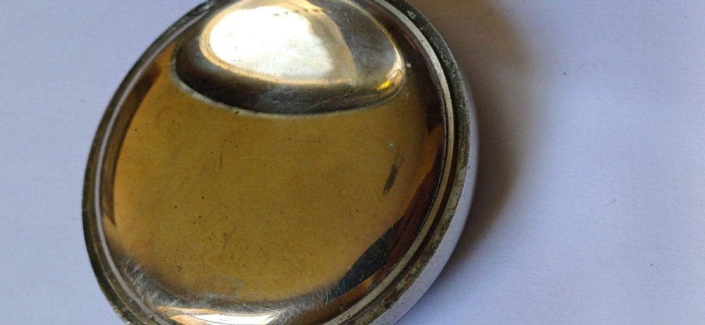 An open-face pocket watch featuring a black dial, luminescent white Arabic numerals, two sub-dials, and a silver-coloured metal case with an onion crown. View VI