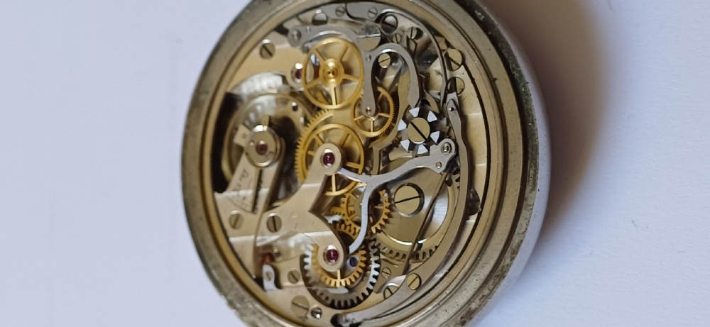 An open-face pocket watch featuring a black dial, luminescent white Arabic numerals, two sub-dials, and a silver-coloured metal case with an onion crown. View IX