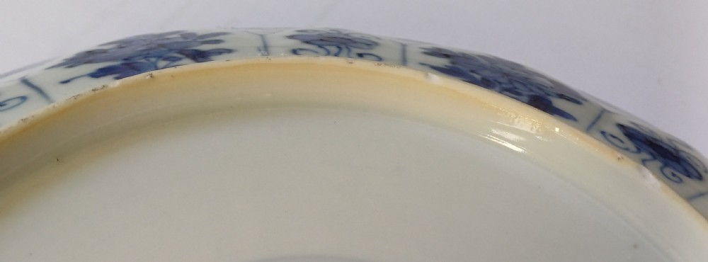 A circular Chinese porcelain dish painted with blue cobalt floral motifs, featuring a barbed rim and radiating moulded petal panels. View VII