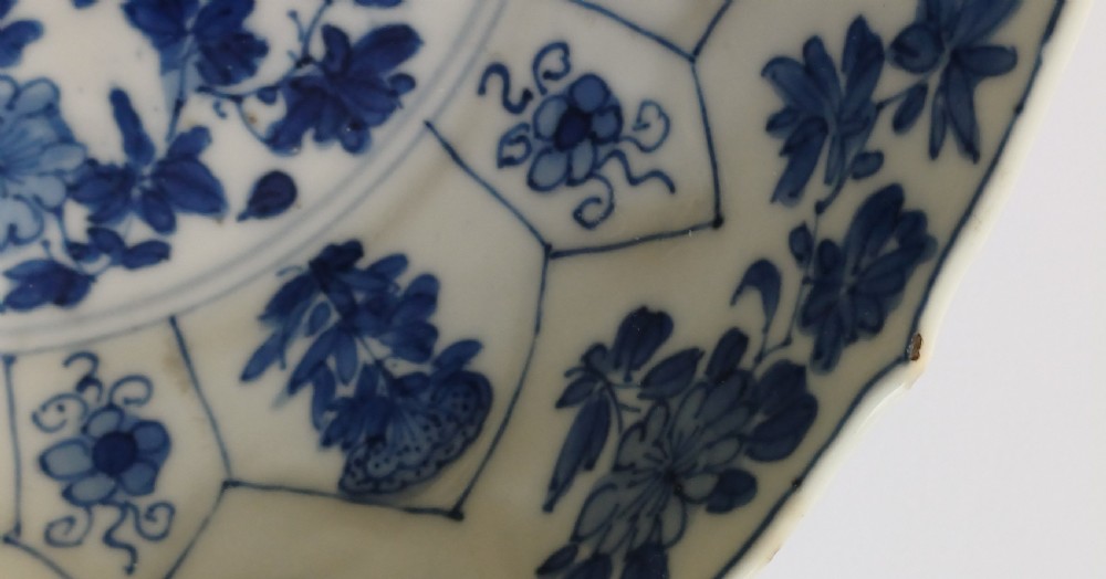 A circular Chinese porcelain dish painted with blue cobalt floral motifs, featuring a barbed rim and radiating moulded petal panels. View XI