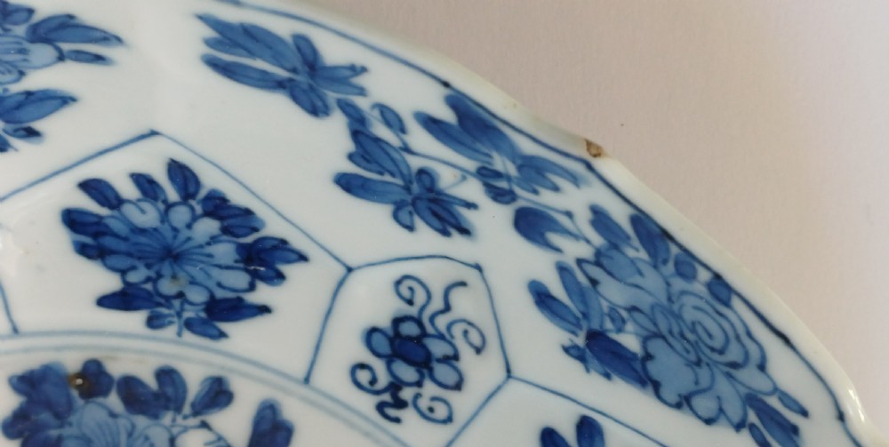 A circular Chinese porcelain dish painted with blue cobalt floral motifs, featuring a barbed rim and radiating moulded petal panels. View XIII