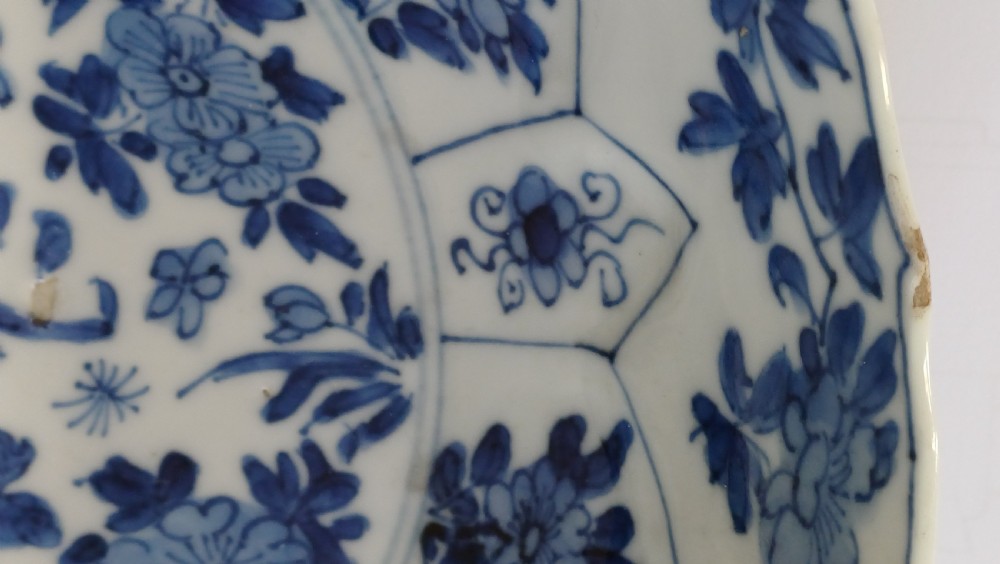 A circular Chinese porcelain dish painted with blue cobalt floral motifs, featuring a barbed rim and radiating moulded petal panels. View XIV