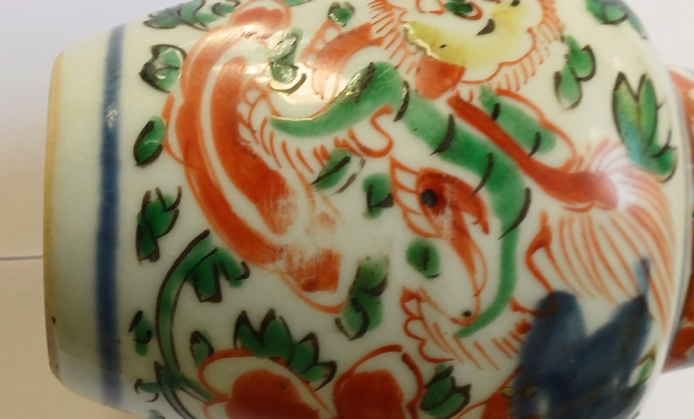 A small 17th-century Chinese Transitional Wucai porcelain jar painted with iron-red, green, and yellow Buddhistic lions amidst foliage on a white background. View IV