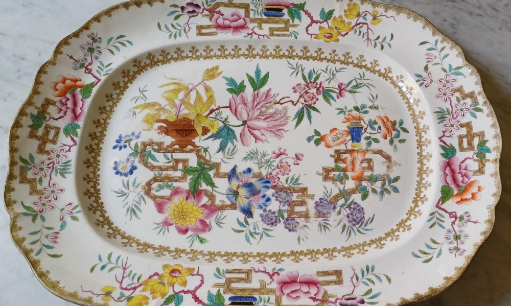 An early Victorian rectangular earthenware platter featuring hand-painted floral motifs in enamel and gilt trim on a scalloped cream ground. View II