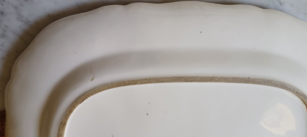An early Victorian rectangular earthenware platter featuring hand-painted floral motifs in enamel and gilt trim on a scalloped cream ground. View XIII
