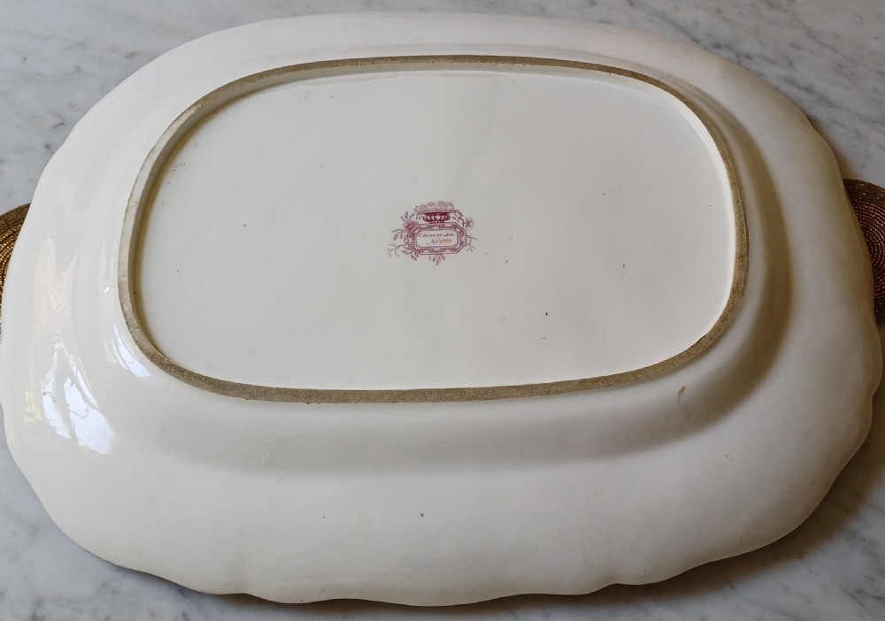 An early Victorian rectangular earthenware platter featuring hand-painted floral motifs in enamel and gilt trim on a scalloped cream ground. View XVI