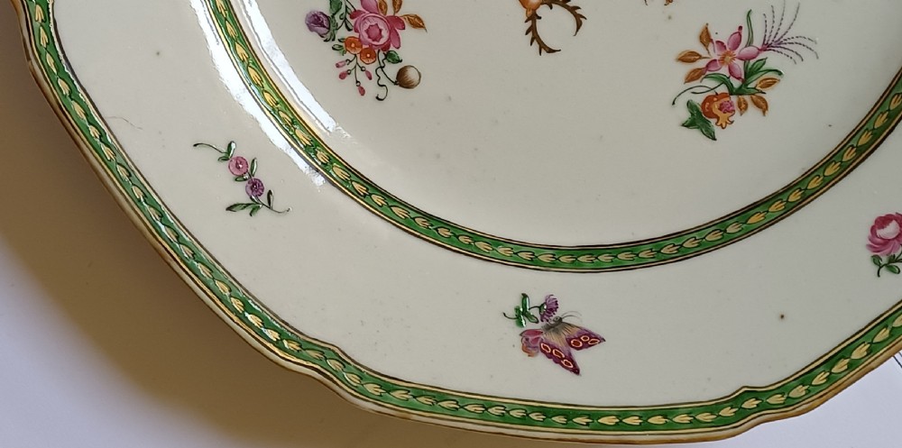An octagonal 18th-century Chinese export porcelain plate decorated with a central heraldic coat of arms, floral sprays, and a green patterned border. View IV