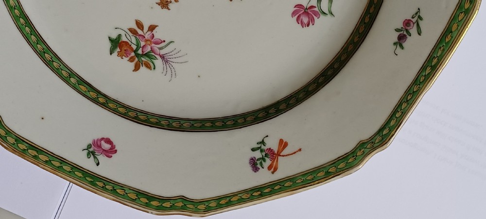 An octagonal 18th-century Chinese export porcelain plate decorated with a central heraldic coat of arms, floral sprays, and a green patterned border. View VI