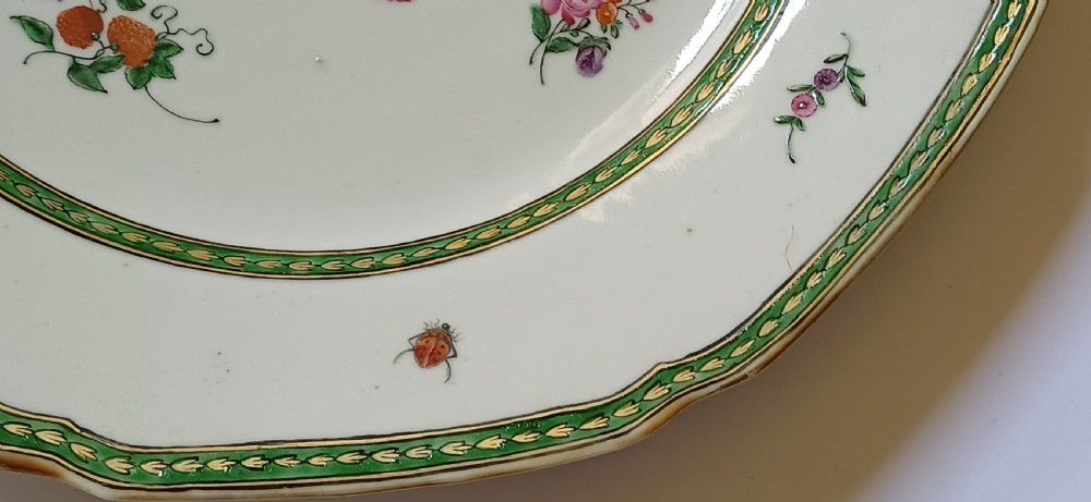 An octagonal 18th-century Chinese export porcelain plate decorated with a central heraldic coat of arms, floral sprays, and a green patterned border. View IX