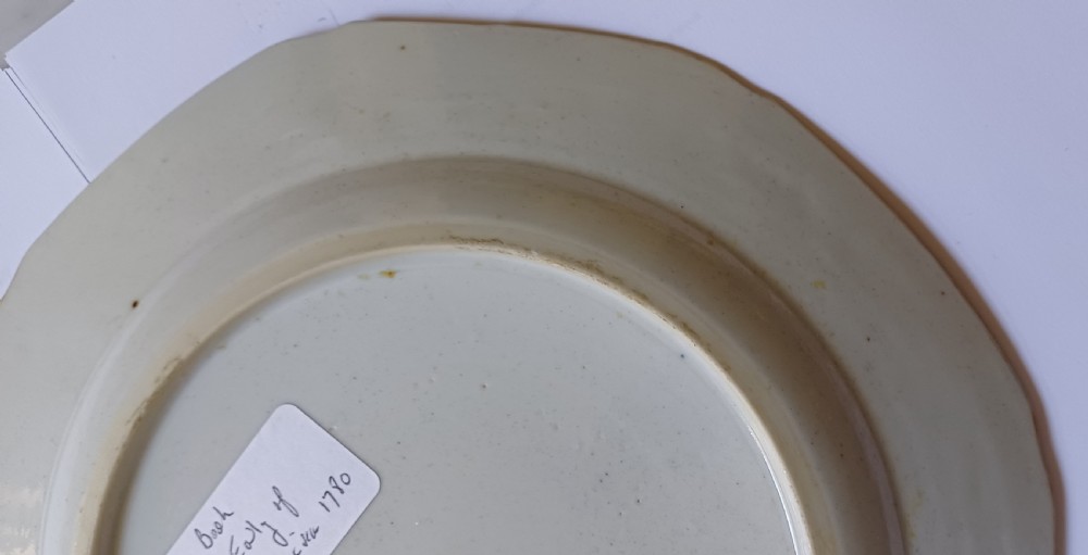 An octagonal 18th-century Chinese export porcelain plate decorated with a central heraldic coat of arms, floral sprays, and a green patterned border. View XVI