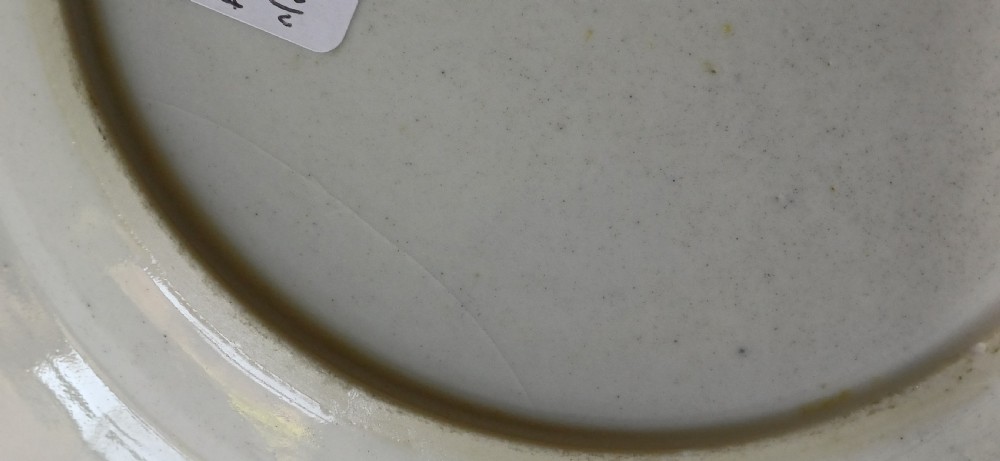 An octagonal 18th-century Chinese export porcelain plate decorated with a central heraldic coat of arms, floral sprays, and a green patterned border. View XVIII