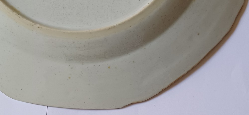 An octagonal 18th-century Chinese export porcelain plate decorated with a central heraldic coat of arms, floral sprays, and a green patterned border. View XXI