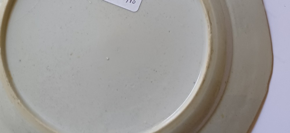 An octagonal 18th-century Chinese export porcelain plate decorated with a central heraldic coat of arms, floral sprays, and a green patterned border. View XXII