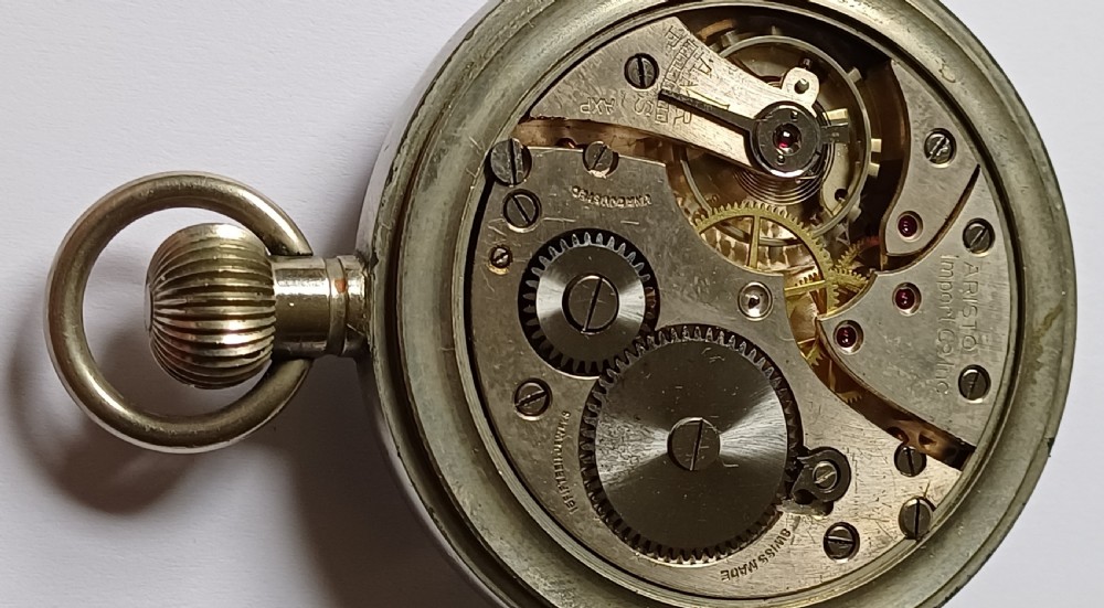An open-face WW2 military pocket watch featuring a white enamel dial with Roman numerals, a subsidiary seconds dial, and a coin-edge bezel. View XIII