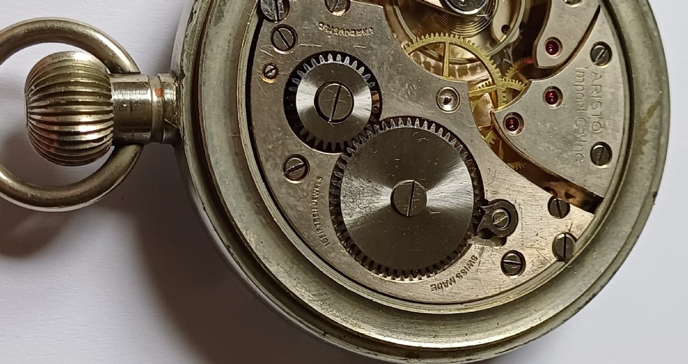 An open-face WW2 military pocket watch featuring a white enamel dial with Roman numerals, a subsidiary seconds dial, and a coin-edge bezel. View XV