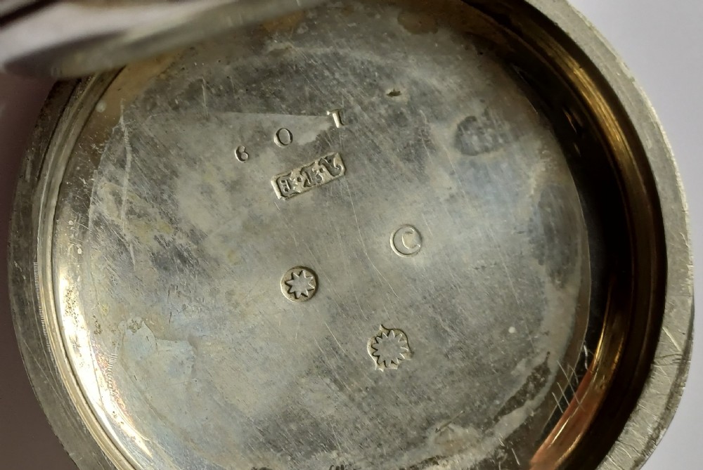 An open-face antique pocket watch featuring a silver-coloured metal casing, cream enamel dial with black Roman numerals, and a gold-toned winding crown. View IX