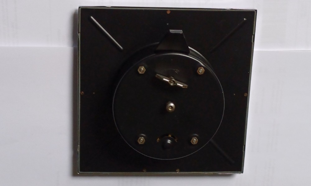 A square mid-century chrome desk clock featuring a cream dial with black Arabic numerals and embossed Alvis and Brooklands branding. View IX