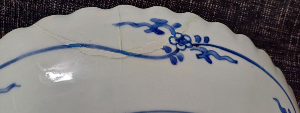 A large round Japanese Arita blue and white porcelain charger with a scalloped rim, hand-painted birds, flowers, and dense scrolling leaf borders. View IV