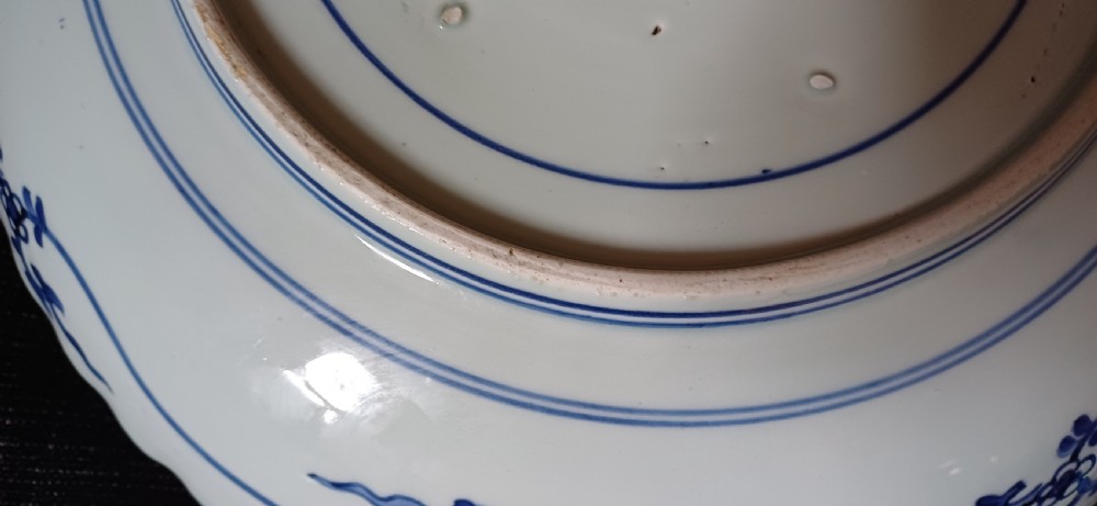A large round Japanese Arita blue and white porcelain charger with a scalloped rim, hand-painted birds, flowers, and dense scrolling leaf borders. View IX