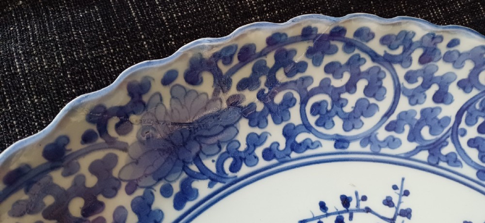 A large round Japanese Arita blue and white porcelain charger with a scalloped rim, hand-painted birds, flowers, and dense scrolling leaf borders. View XI